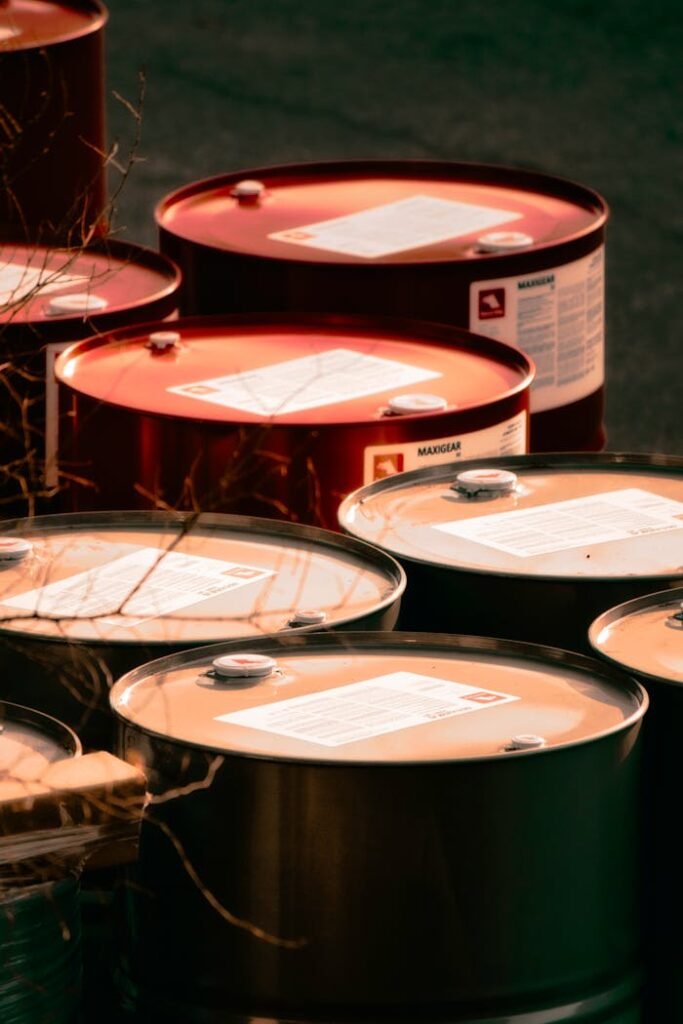 pexels-photo-15730185 Multiple red and silver steel barrels arranged outdoors for industrial storage.